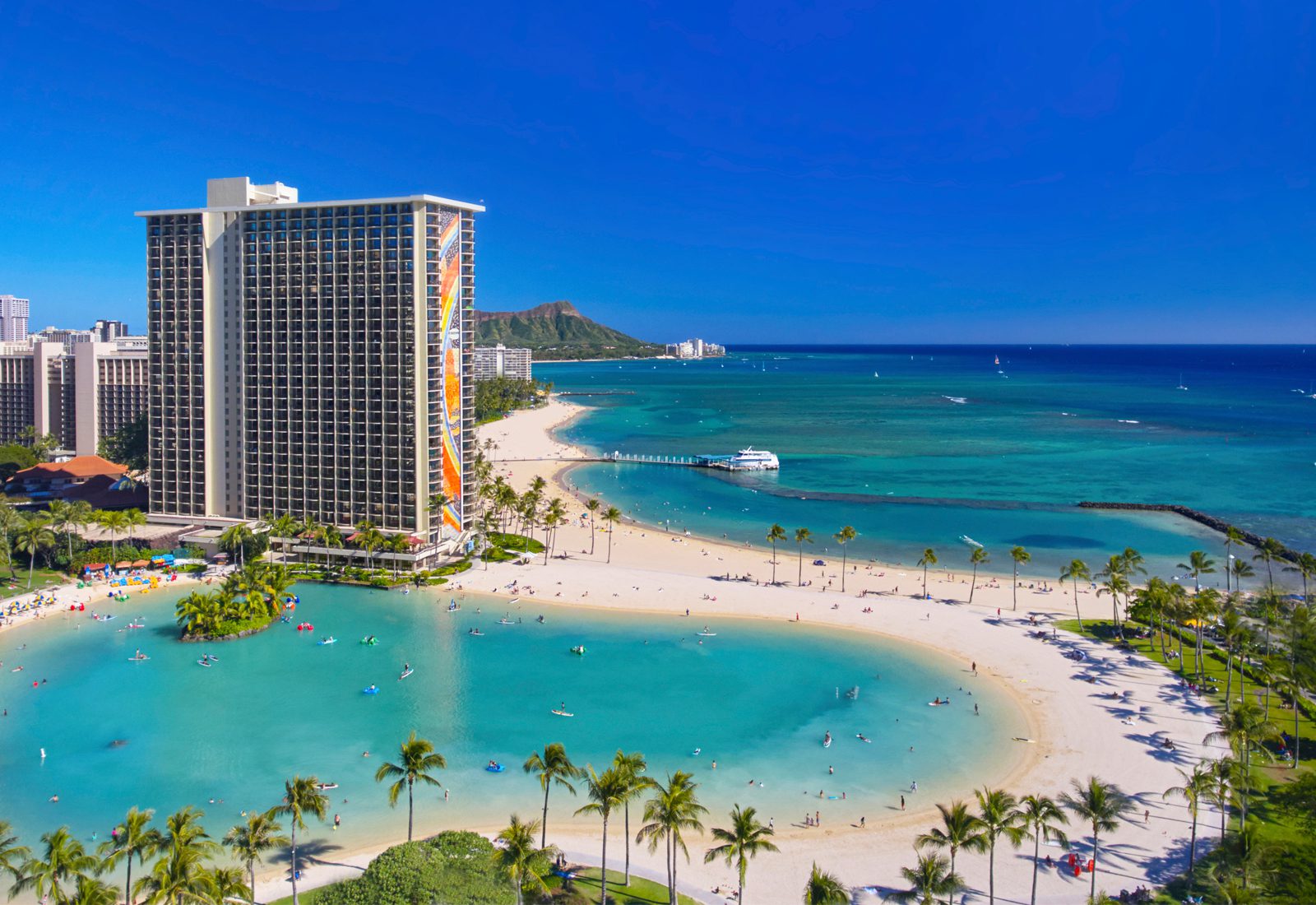 Rainbow Tower Building on beach with large lagoon in foreground and beach and sand next to the tower.