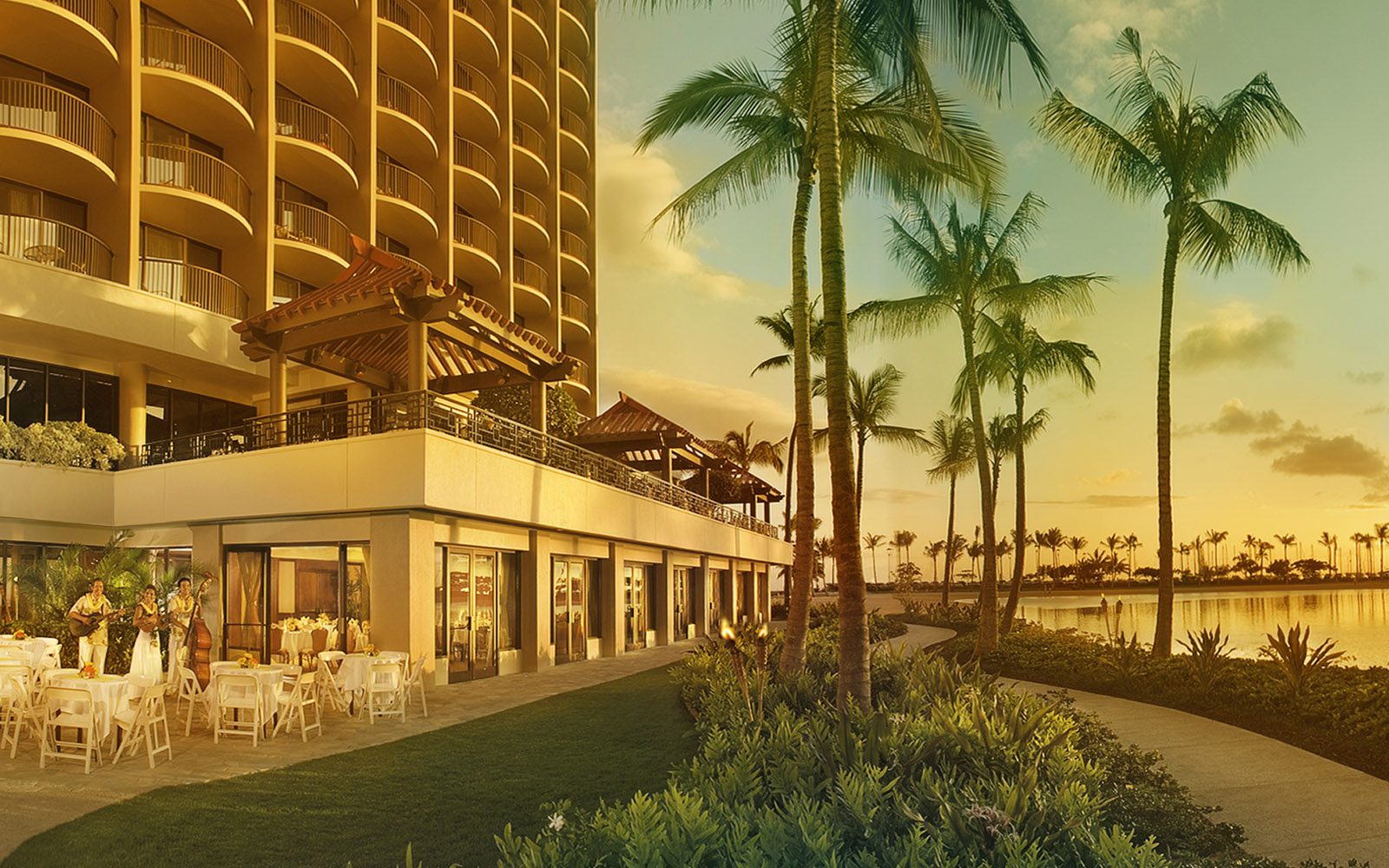 Sunset photo of Rainbow Suite meeting rooms which shows the outdoor patio and the grassy area in front of the lagoon.