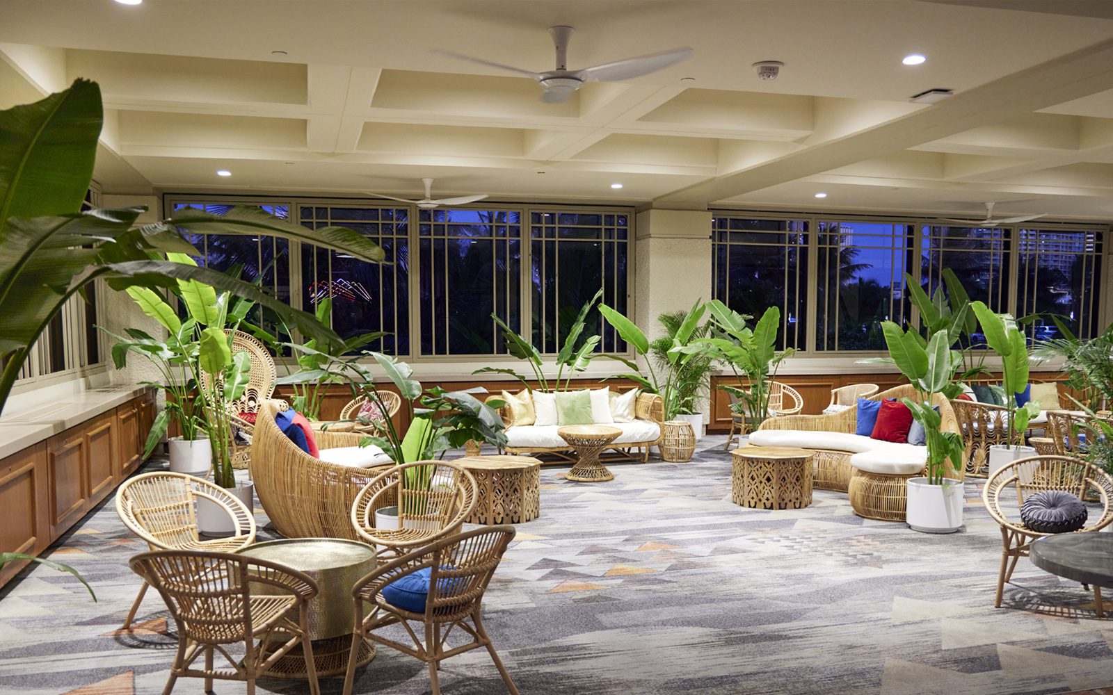 Palace Lounge decorated with island furnishings, wicker chairs and palm plants.